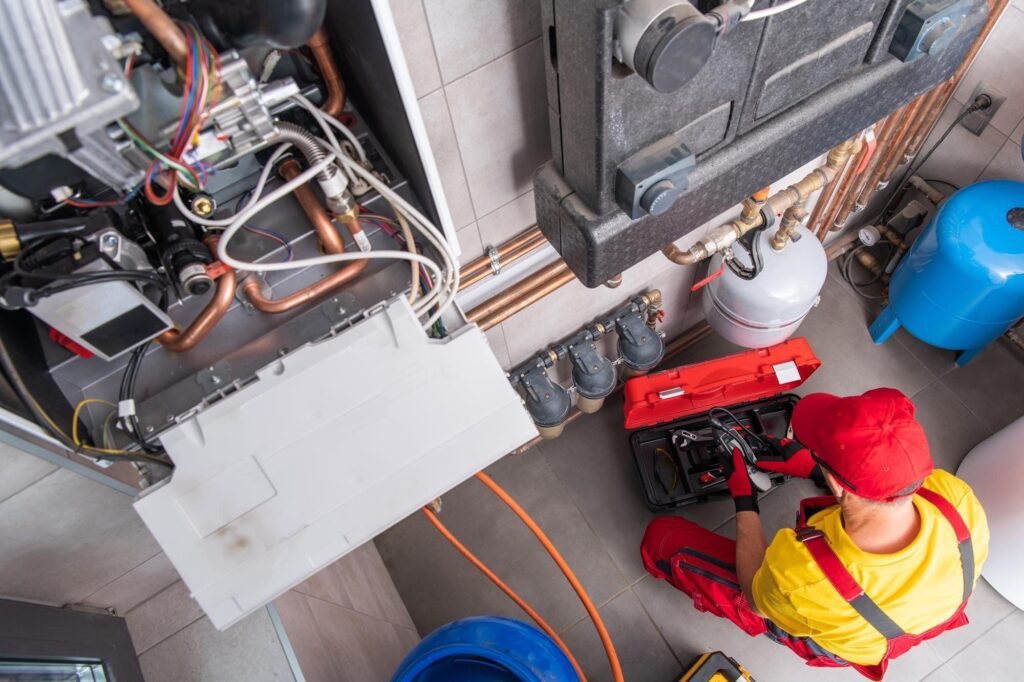 An HVAC technician performing home heating system maintenance.