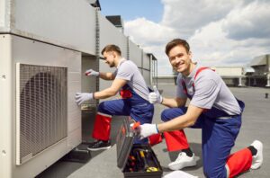 HVAC Technicians Smiling for the Camera While fixing an HVAC system